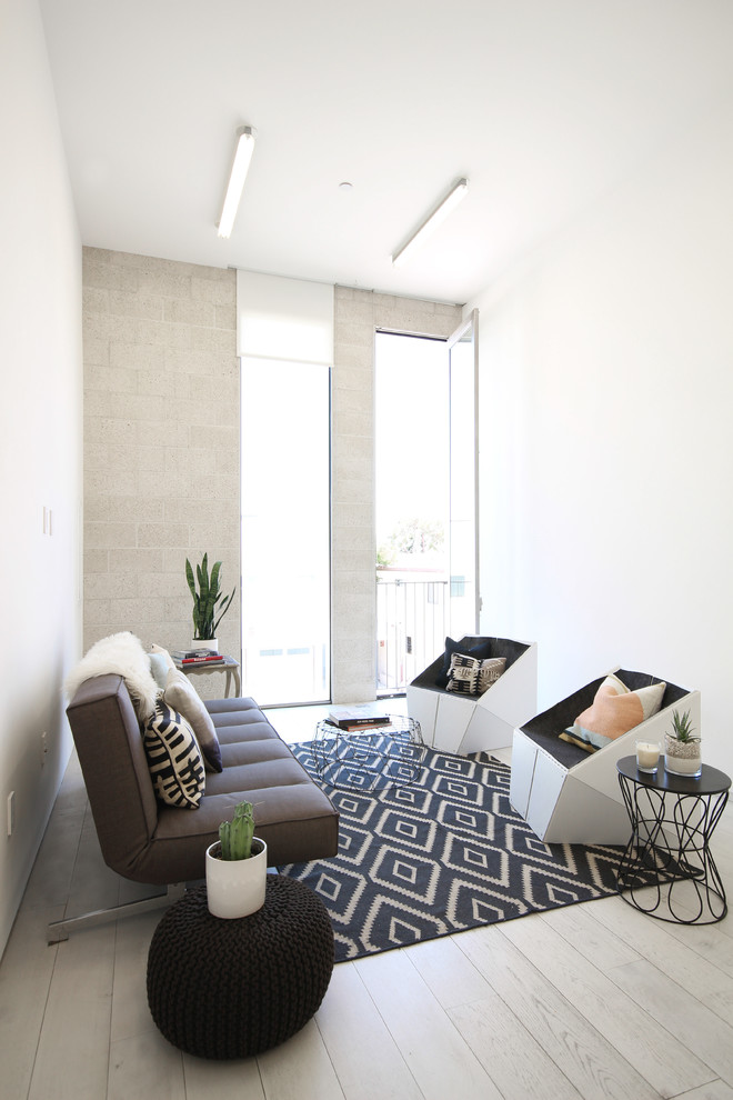 Mid-sized scandinavian living room in Los Angeles with white walls and light hardwood floors.