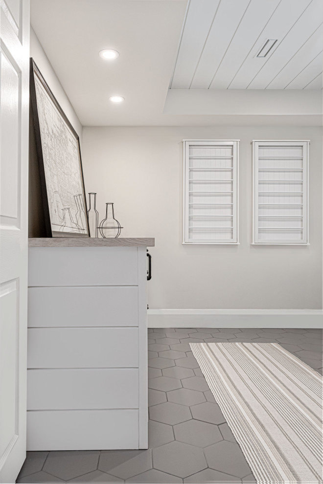 Photo of a medium sized farmhouse separated utility room in Toronto with a built-in sink, flat-panel cabinets, white cabinets, laminate countertops, grey walls, porcelain flooring, a side by side washer and dryer, grey floors and a timber clad ceiling.