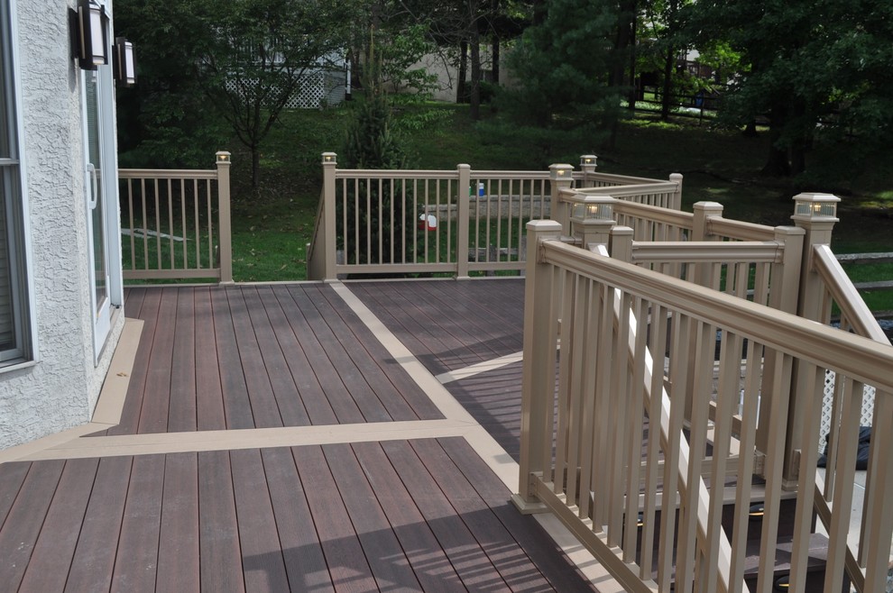 Example of a mid-sized transitional backyard deck design with no cover
