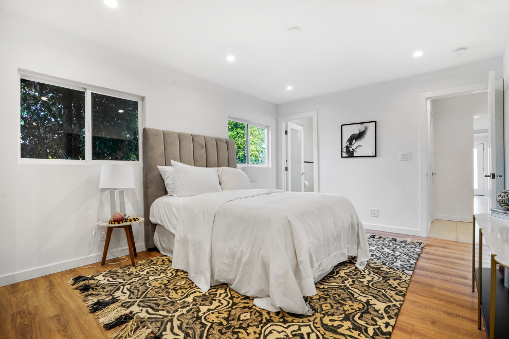 Foto di una camera degli ospiti contemporanea di medie dimensioni con pareti bianche, pavimento in legno massello medio e pavimento marrone