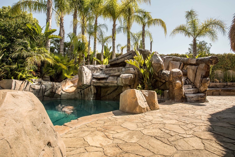Inspiration for a large tropical backyard patio in Los Angeles with concrete pavers.