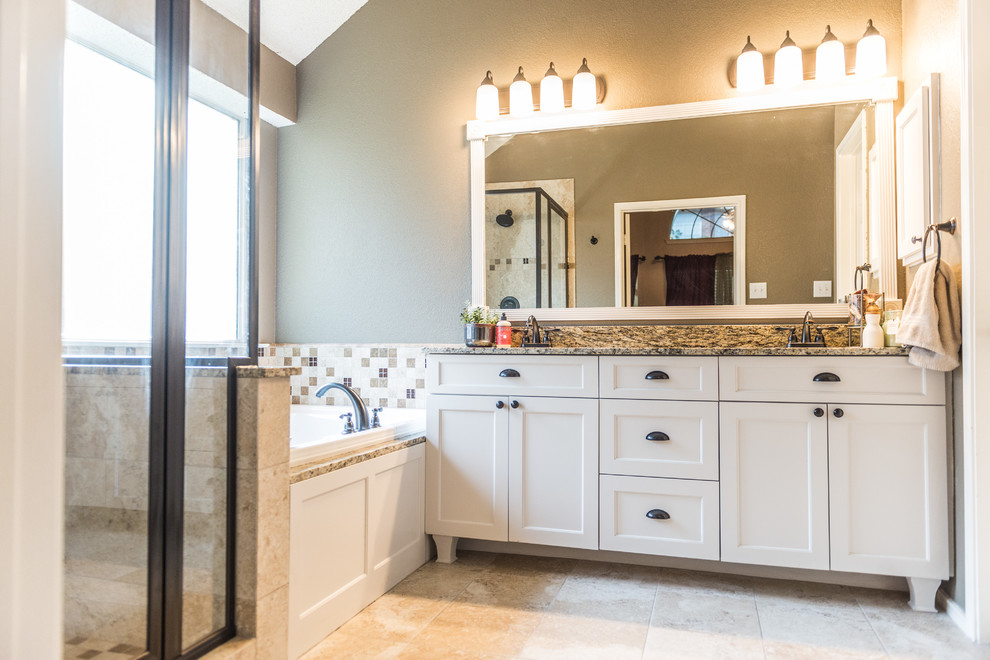 This is an example of a traditional master bathroom in Dallas with an undermount sink, furniture-like cabinets, white cabinets, granite benchtops, a corner tub, a corner shower, beige tile, ceramic tile, brown walls and ceramic floors.