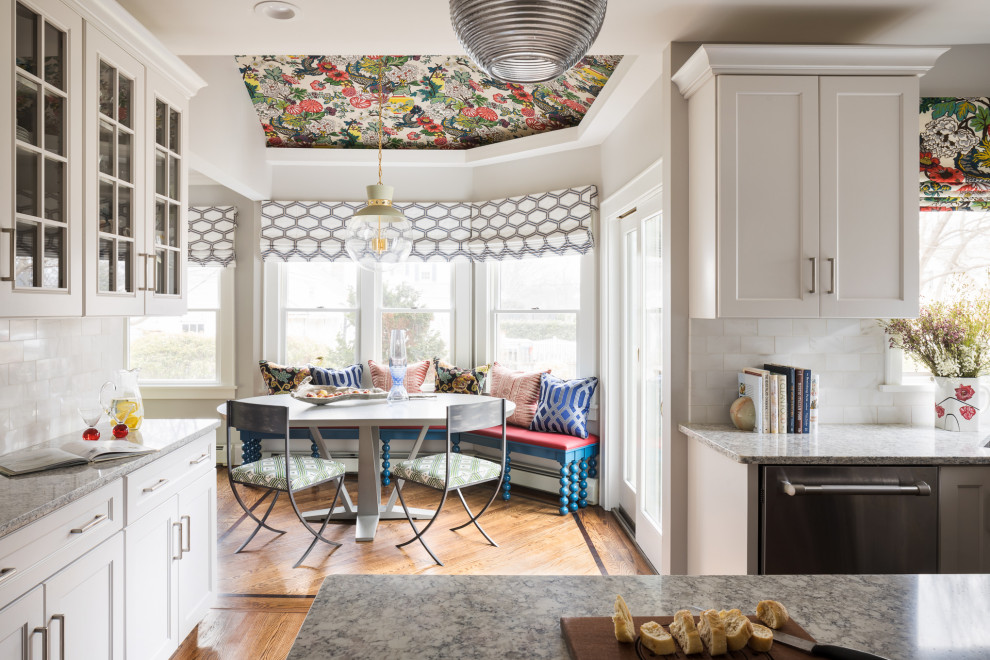 Idéer för ett mellanstort modernt grå u-kök, med en undermonterad diskho, skåp i shakerstil, vita skåp, granitbänkskiva, vitt stänkskydd, stänkskydd i keramik, rostfria vitvaror, mellanmörkt trägolv, en köksö och brunt golv