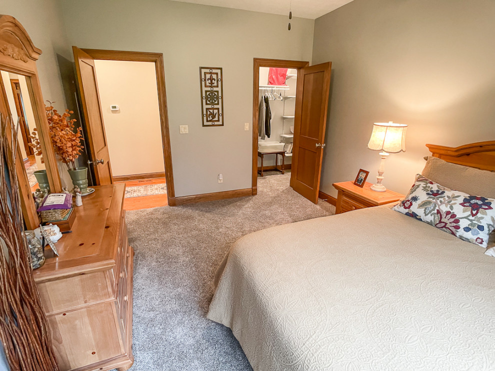 他の地域にある中くらいなトラディショナルスタイルのおしゃれな客用寝室 (ベージュの壁、カーペット敷き、マルチカラーの床、白い天井) のインテリア