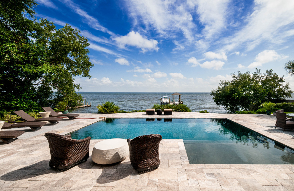 Inspiration for a beach style backyard l-shaped pool in Miami with tile.