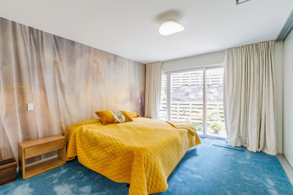 Inspiration for a mid-sized contemporary master bedroom in Auckland with white walls, carpet and blue floor.