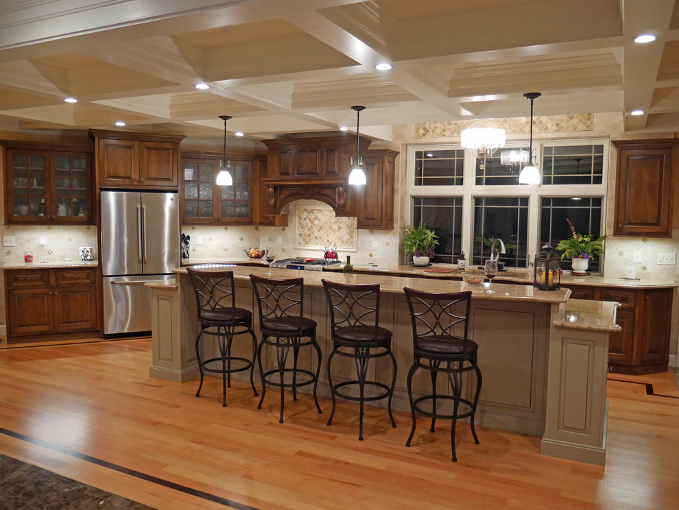 This is an example of a large traditional l-shaped eat-in kitchen in Boston with an undermount sink, beaded inset cabinets, dark wood cabinets, granite benchtops, brown splashback, stone tile splashback, stainless steel appliances, dark hardwood floors, with island and brown floor.
