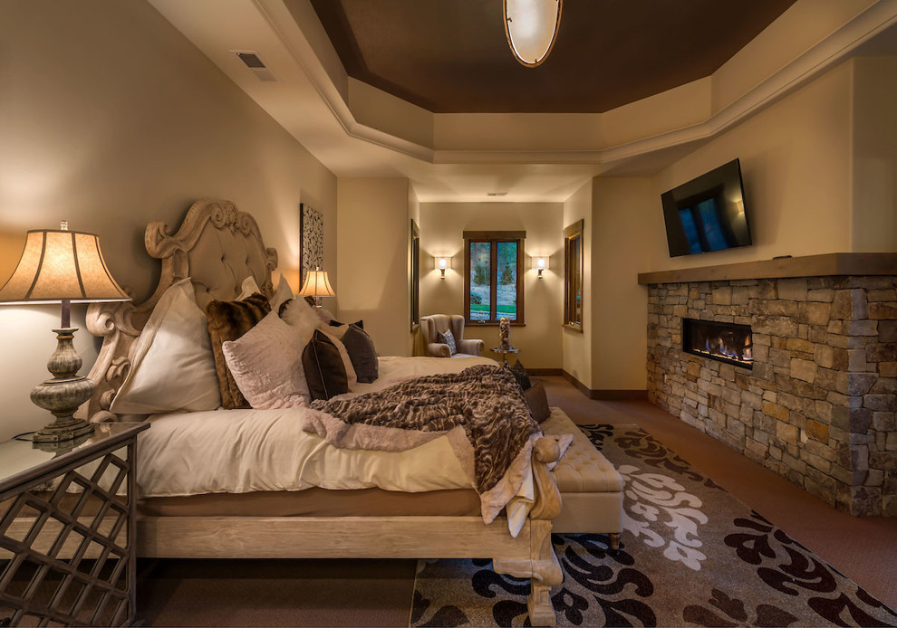 Inspiration for a mid-sized transitional master bedroom in Other with beige walls, carpet, a standard fireplace and a stone fireplace surround.