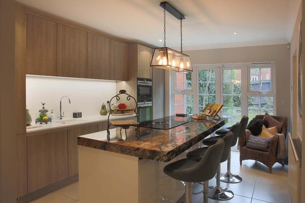 Photo of a small contemporary single-wall separate kitchen in Essex with an undermount sink, flat-panel cabinets, light wood cabinets, quartzite benchtops, white splashback, stone slab splashback, panelled appliances, porcelain floors and with island.