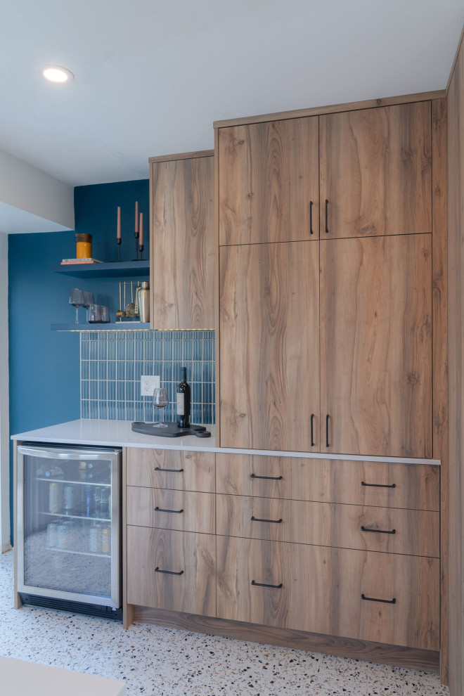 Example of a small transitional u-shaped terrazzo floor and white floor eat-in kitchen design in Vancouver with a farmhouse sink, flat-panel cabinets, light wood cabinets, quartz countertops, blue backsplash, porcelain backsplash, stainless steel appliances, an island and white countertops