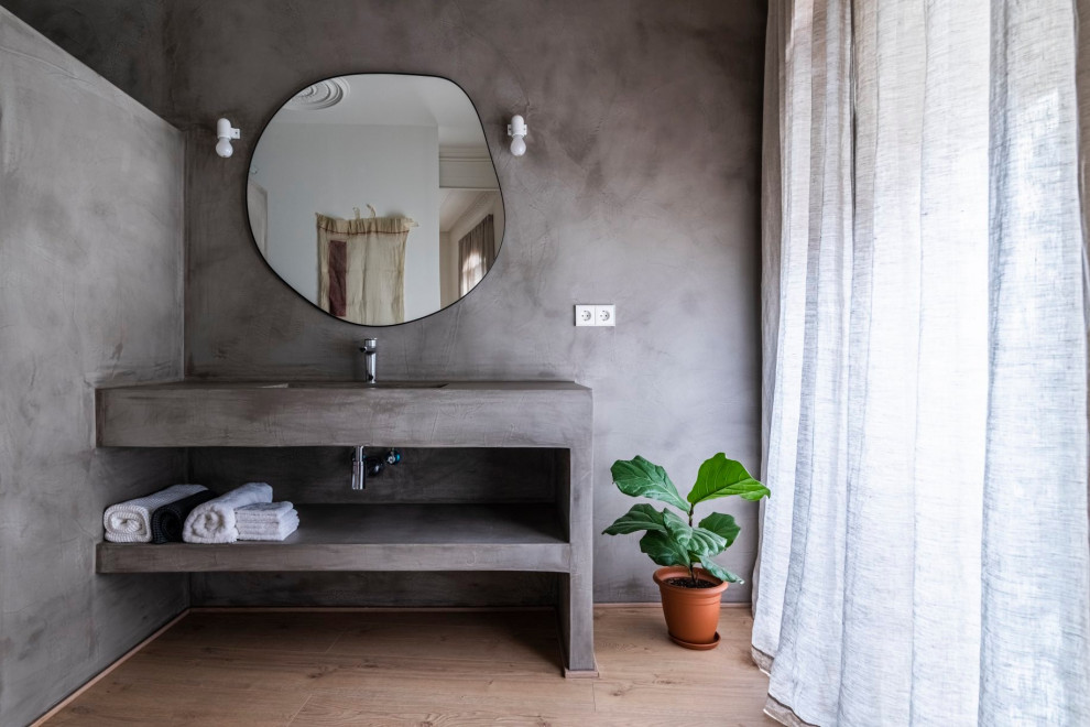 Inredning av ett asiatiskt grå grått en-suite badrum, med öppna hyllor, grå skåp, en öppen dusch, ljust trägolv, ett integrerad handfat, bänkskiva i betong, brunt golv och med dusch som är öppen