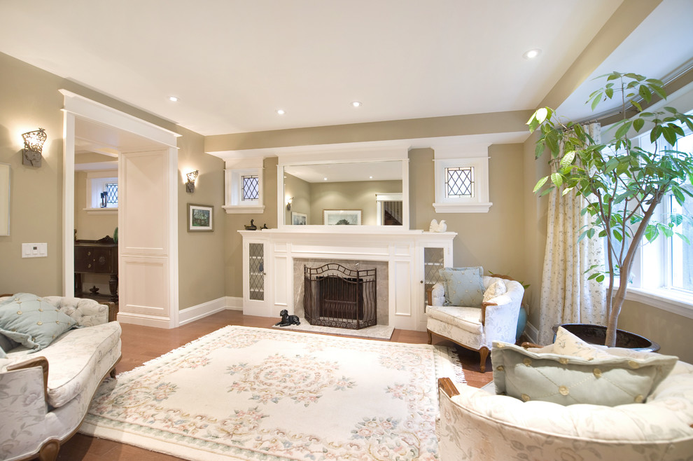 This is an example of a mid-sized traditional formal enclosed living room in Toronto with yellow walls, medium hardwood floors, a standard fireplace and a concrete fireplace surround.