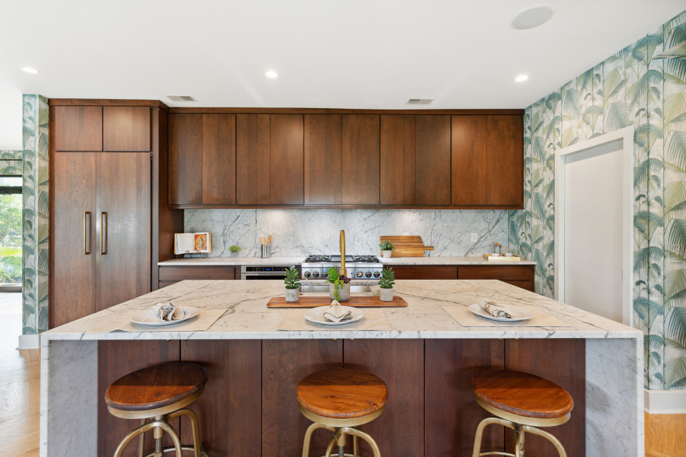 Cette image montre une cuisine vintage en bois foncé avec un placard à porte plane, plan de travail en marbre, une crédence en marbre, un électroménager en acier inoxydable et îlot.