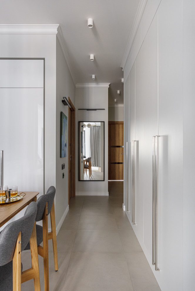 Свежая идея для дизайна: коридор: освещение в современном стиле с белыми стенами, полом из керамогранита и серым полом - отличное фото интерьера
