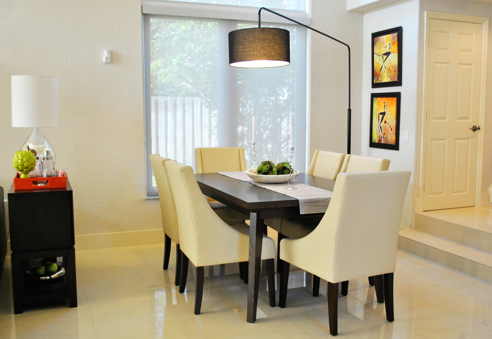 Photo of a mid-sized contemporary kitchen/dining combo in Miami with beige walls and porcelain floors.
