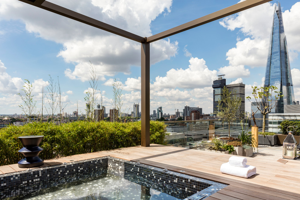 Inspiration for a contemporary rooftop pool in London with a hot tub and decking.