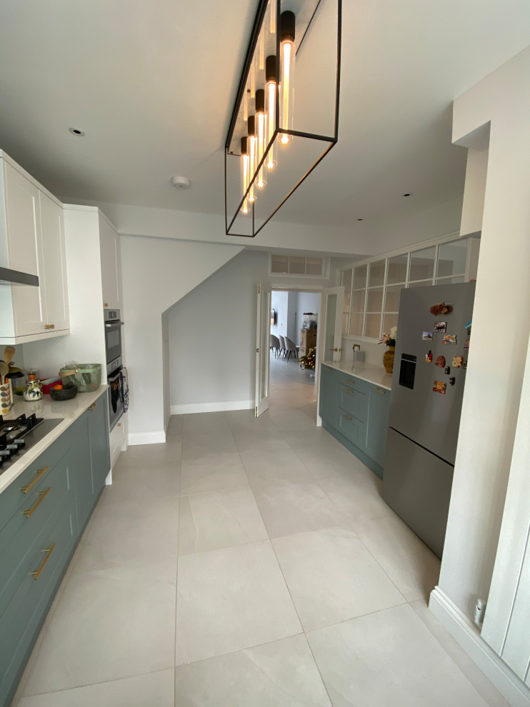 Design ideas for a large contemporary galley kitchen/diner in London with quartz worktops, white splashback, porcelain flooring and no island.