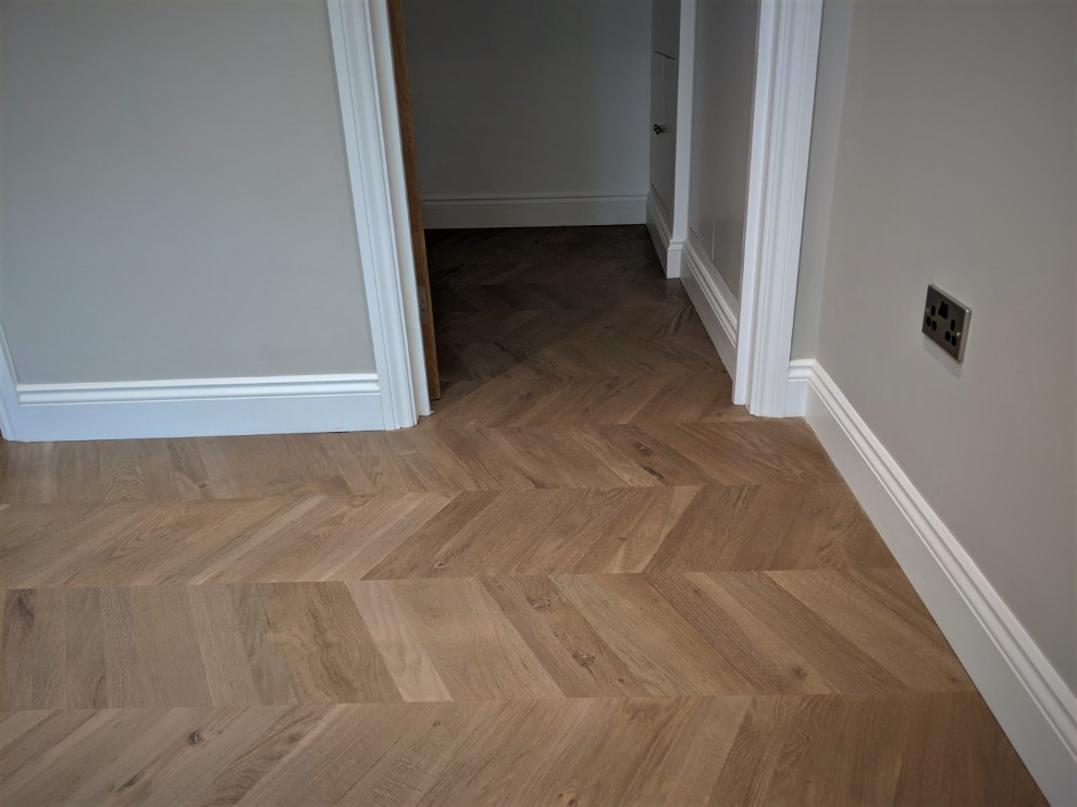 Large contemporary hallway in Hertfordshire with grey walls, light hardwood floors and brown floor.