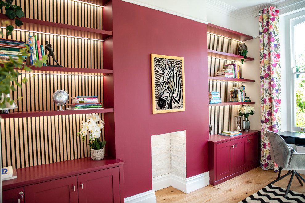 Idéer för stora funkis hemmabibliotek, med röda väggar, ljust trägolv, en standard öppen spis, en spiselkrans i trä, ett fristående skrivbord och orange golv