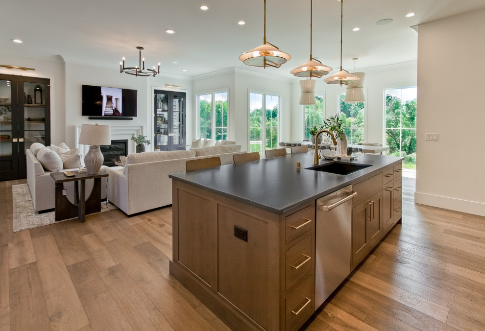 Photo of a classic open plan kitchen in Other with a submerged sink, recessed-panel cabinets, medium wood cabinets, soapstone worktops, stainless steel appliances, medium hardwood flooring, an island, brown floors and black worktops.