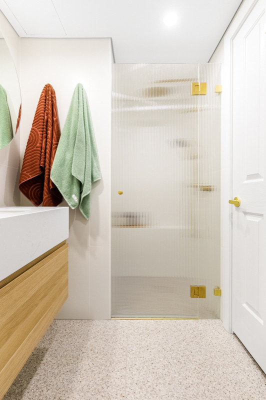 Exempel på ett mellanstort modernt vit vitt badrum med dusch, med släta luckor, skåp i ljust trä, en dusch i en alkov, en toalettstol med separat cisternkåpa, flerfärgad kakel, mosaik, vita väggar, ett undermonterad handfat, beiget golv och dusch med gångjärnsdörr