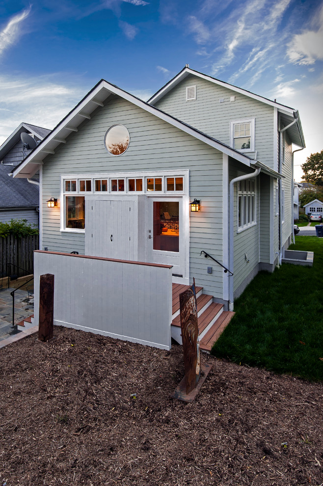 Mid-sized traditional two-storey green house exterior in DC Metro with wood siding, a gable roof and a shingle roof.