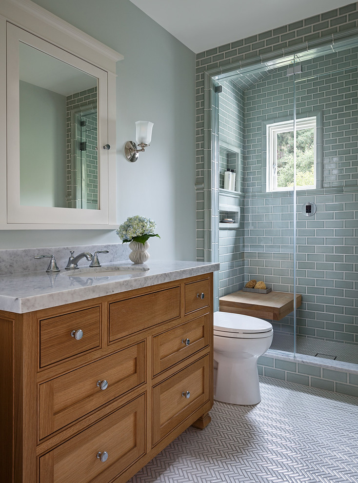 Inspiration for a mid-sized arts and crafts 3/4 bathroom in San Francisco with shaker cabinets, medium wood cabinets, an alcove shower, a two-piece toilet, green tile, subway tile, green walls, porcelain floors, an undermount sink, marble benchtops, white floor and a hinged shower door.