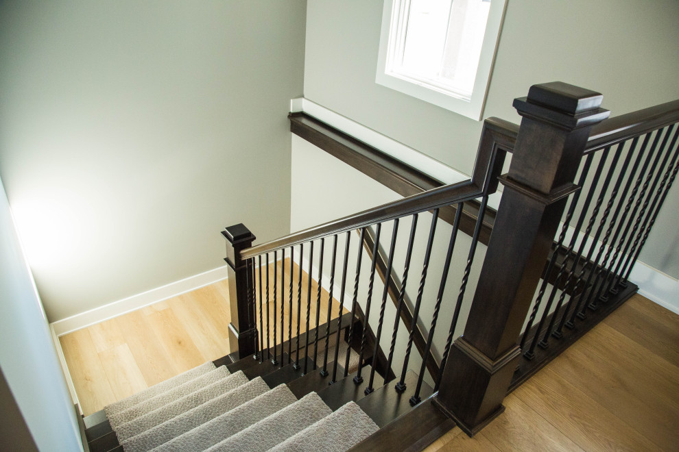 На фото: п-образная деревянная лестница среднего размера в классическом стиле с ступенями с ковровым покрытием и перилами из смешанных материалов с