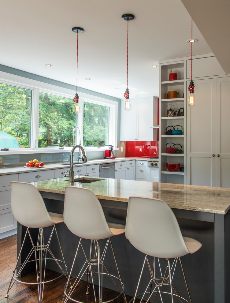 Mid-sized transitional u-shaped eat-in kitchen in DC Metro with an undermount sink, shaker cabinets, white cabinets, marble benchtops, red splashback, glass sheet splashback, stainless steel appliances, dark hardwood floors and with island.