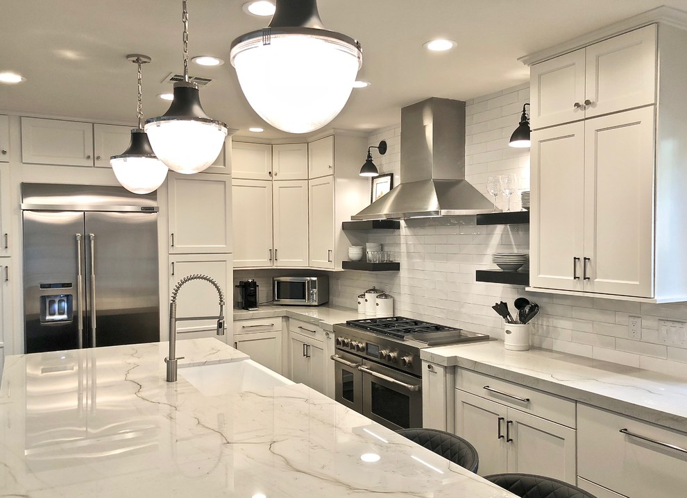 Photo of a mid-sized country l-shaped separate kitchen in Las Vegas with a farmhouse sink, shaker cabinets, white cabinets, marble benchtops, white splashback, subway tile splashback, stainless steel appliances, concrete floors, with island, grey floor and white benchtop.