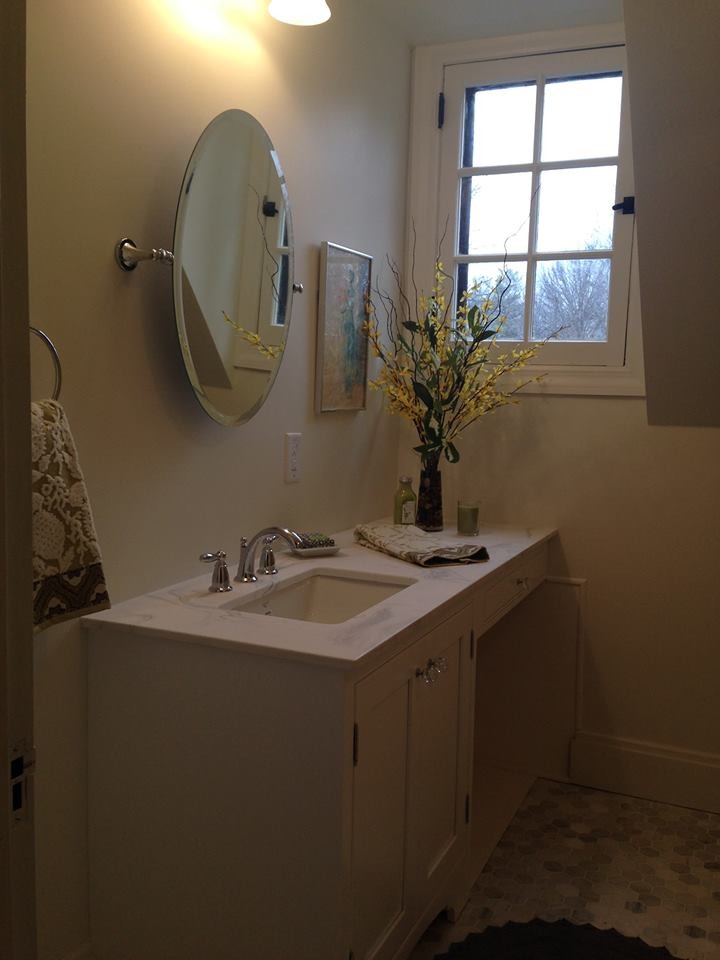 Photo of a small transitional kids bathroom in Cleveland with recessed-panel cabinets, white cabinets, a drop-in tub, an alcove shower, a two-piece toilet, white tile, porcelain tile, white walls, marble floors, an undermount sink and solid surface benchtops.