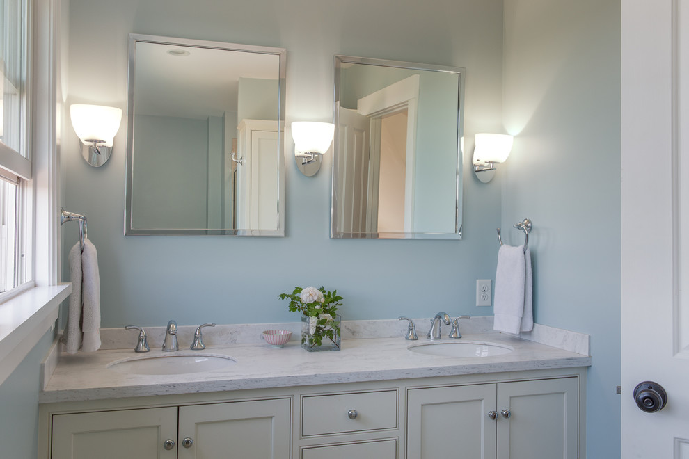 This is an example of a small beach style master bathroom in Portland Maine with an undermount sink, recessed-panel cabinets, white cabinets, marble benchtops and blue walls.