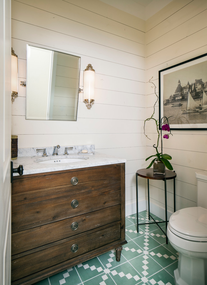 Photo of a mid-sized beach style 3/4 bathroom in San Francisco with flat-panel cabinets, dark wood cabinets, a two-piece toilet, ceramic tile, white walls, ceramic floors, an undermount sink and marble benchtops.