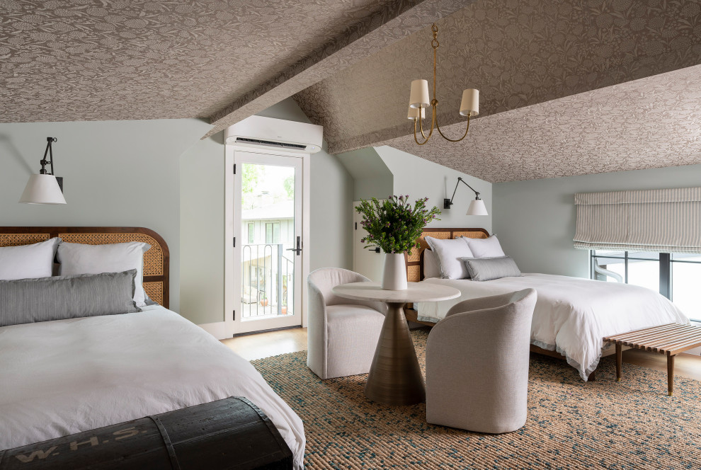 Klassisches Gästezimmer ohne Kamin mit blauer Wandfarbe, hellem Holzboden, braunem Boden, freigelegten Dachbalken, gewölbter Decke und Tapetendecke in Austin