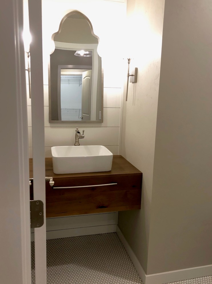 Photo of a mid-sized contemporary powder room in Other with open cabinets, medium wood cabinets, grey walls, cement tiles, wood benchtops, white floor and brown benchtops.