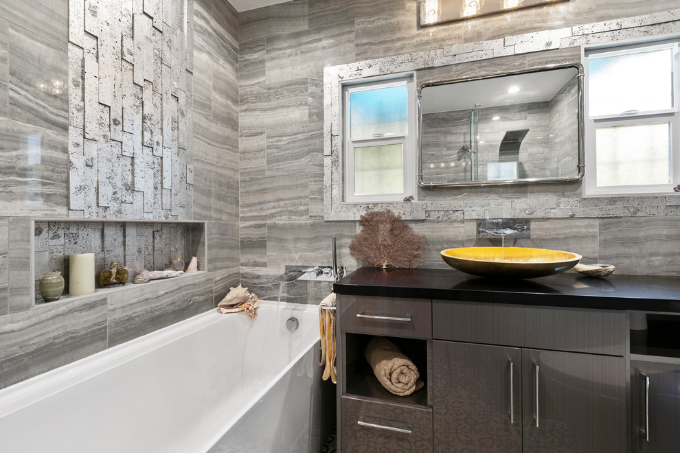 This is an example of a small beach style master bathroom in Los Angeles with flat-panel cabinets, black cabinets, a corner tub, a corner shower, a bidet, gray tile, porcelain tile, grey walls, cement tiles, a vessel sink, engineered quartz benchtops, multi-coloured floor and black benchtops.