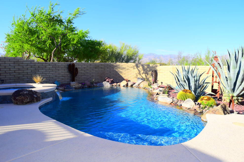 Pool fountain - large rustic backyard concrete paver and kidney-shaped pool fountain idea in Phoenix