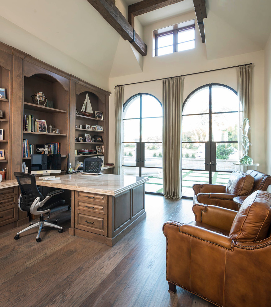 Example of a large tuscan built-in desk light wood floor study room design in Dallas with beige walls and no fireplace