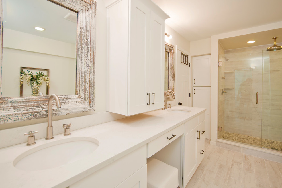 This is an example of a mid-sized country master bathroom in Detroit with shaker cabinets, white cabinets, a drop-in tub, a double shower, a one-piece toilet, gray tile, ceramic tile, white walls, ceramic floors, an undermount sink and quartzite benchtops.