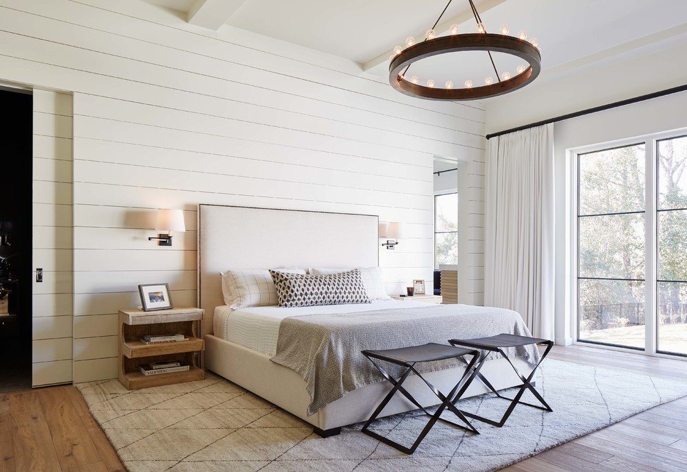 Photo of a country master bedroom in Charlotte with white walls and light hardwood floors.