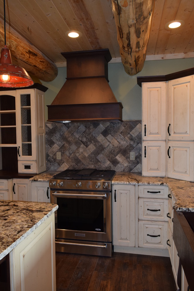 Eat-in kitchen - rustic u-shaped dark wood floor eat-in kitchen idea with a farmhouse sink, raised-panel cabinets, white cabinets, granite countertops, beige backsplash, stone tile backsplash, stainless steel appliances and an island