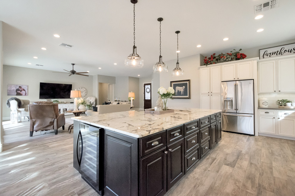 Design ideas for a large country l-shaped open plan kitchen in Phoenix with a farmhouse sink, raised-panel cabinets, white cabinets, granite benchtops, white splashback, subway tile splashback, stainless steel appliances, porcelain floors, with island and grey floor.
