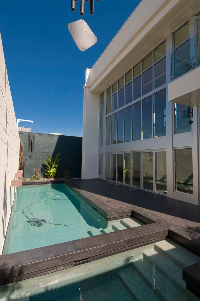Inspiration for a mid-sized contemporary side yard rectangular lap pool in Houston with a hot tub and tile.