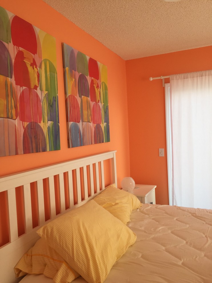 Inspiration for a beach style master bedroom in Atlanta with orange walls, vinyl floors and brown floor.