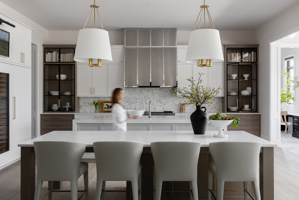 Example of a l-shaped light wood floor and gray floor enclosed kitchen design in Orlando with an undermount sink, recessed-panel cabinets, medium tone wood cabinets, gray backsplash, paneled appliances, two islands and white countertops