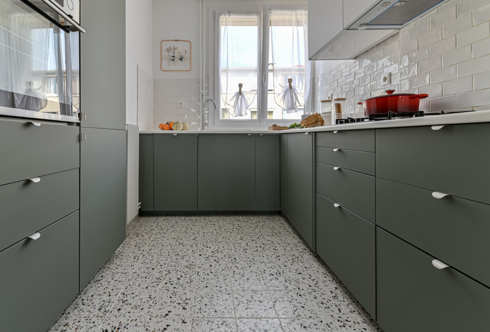 Design ideas for a small contemporary u-shaped separate kitchen in Paris with an undermount sink, flat-panel cabinets, green cabinets, laminate benchtops, white splashback, terra-cotta splashback, white appliances, ceramic floors, no island, multi-coloured floor and white benchtop.