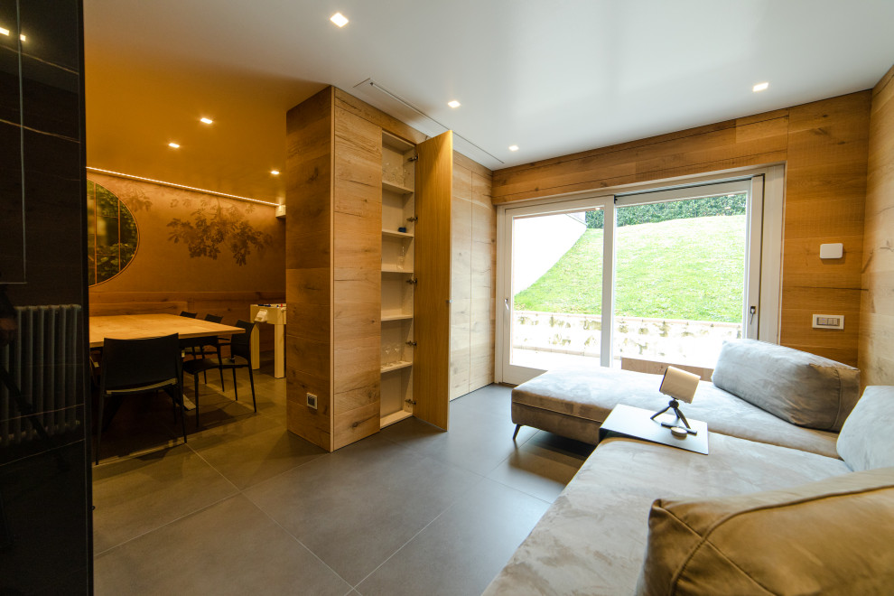 Immagine di un grande armadio incassato unisex minimalista con pavimento in gres porcellanato, pavimento grigio, soffitto ribassato, ante a filo e ante in legno chiaro