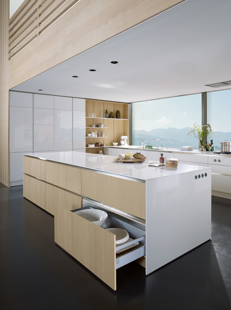Design ideas for a large contemporary galley open plan kitchen in Munich with flat-panel cabinets, white cabinets, stainless steel benchtops, beige splashback, slate floors, with island and black floor.
