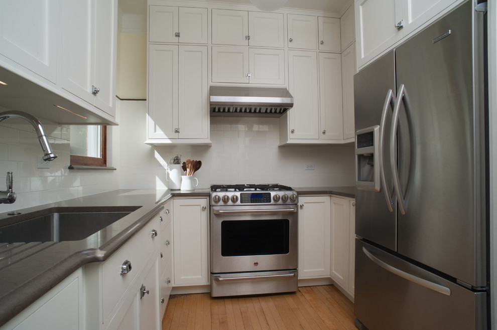 Design ideas for a small traditional u-shaped separate kitchen in Chicago with an undermount sink, shaker cabinets, white cabinets, quartz benchtops, white splashback, subway tile splashback, stainless steel appliances and light hardwood floors.
