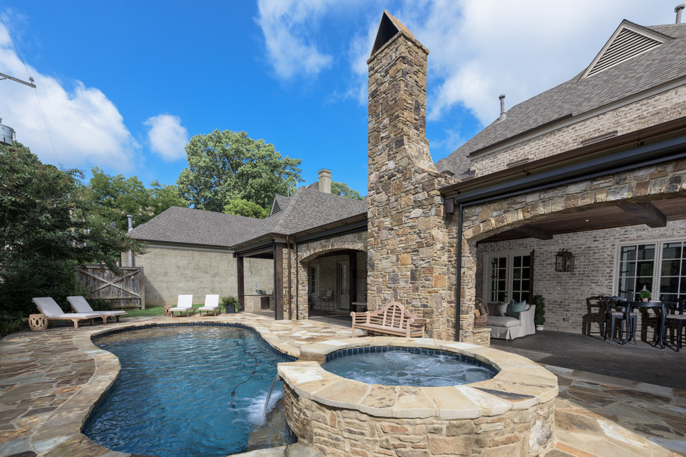 Pool fountain - large backyard stone and custom-shaped natural pool fountain idea